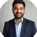 Photo of Ahmed Khan, a man in professional attire with a gentle smile.